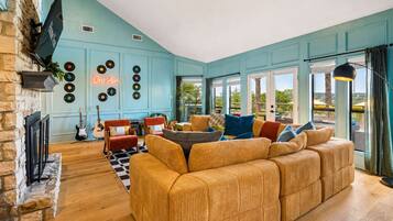 A cozy living room with a large sofa, a fireplace, and a wall decorated with vinyl records.