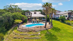 Una propiedad residencial con piscina, un patio cubierto y un patio cercado.