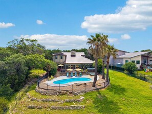Ein Wohnhaus mit Schwimmbad, überdachter Terrasse und umzäunter Garten.