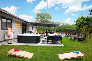 Un patio exterior moderno con un jacuzzi, una zona de estar y un cartel que dice 'San Antonio Southern Spice'.
