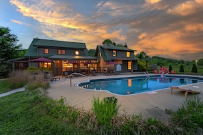 A two-story building with a swimming pool, outdoor seating, and a covered patio area. - 7 Br Sleeps 20 Sport Court Pool Hot Tub Playground (Arden)