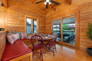A wooden interior with a dining table, red chairs, and a bench with cushions. - 7 Br Sleeps 20 Sport Court Pool Hot Tub Playground (Arden)