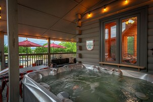 Et boblebadområde med udsigt til en pool og udendørs siddepladser.