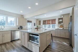 A modern kitchen with a central island, built-in appliances, and ample storage cabinets. - Lakefront Luxury - Boat Slip - Kayaks - Game Room (Waleska)