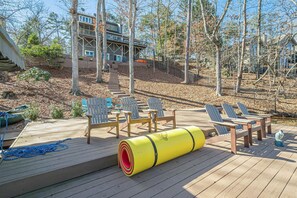 Eine Holzterrasse mit Gartenmöbeln und einem gelben, zylindrischen Gegenstand.