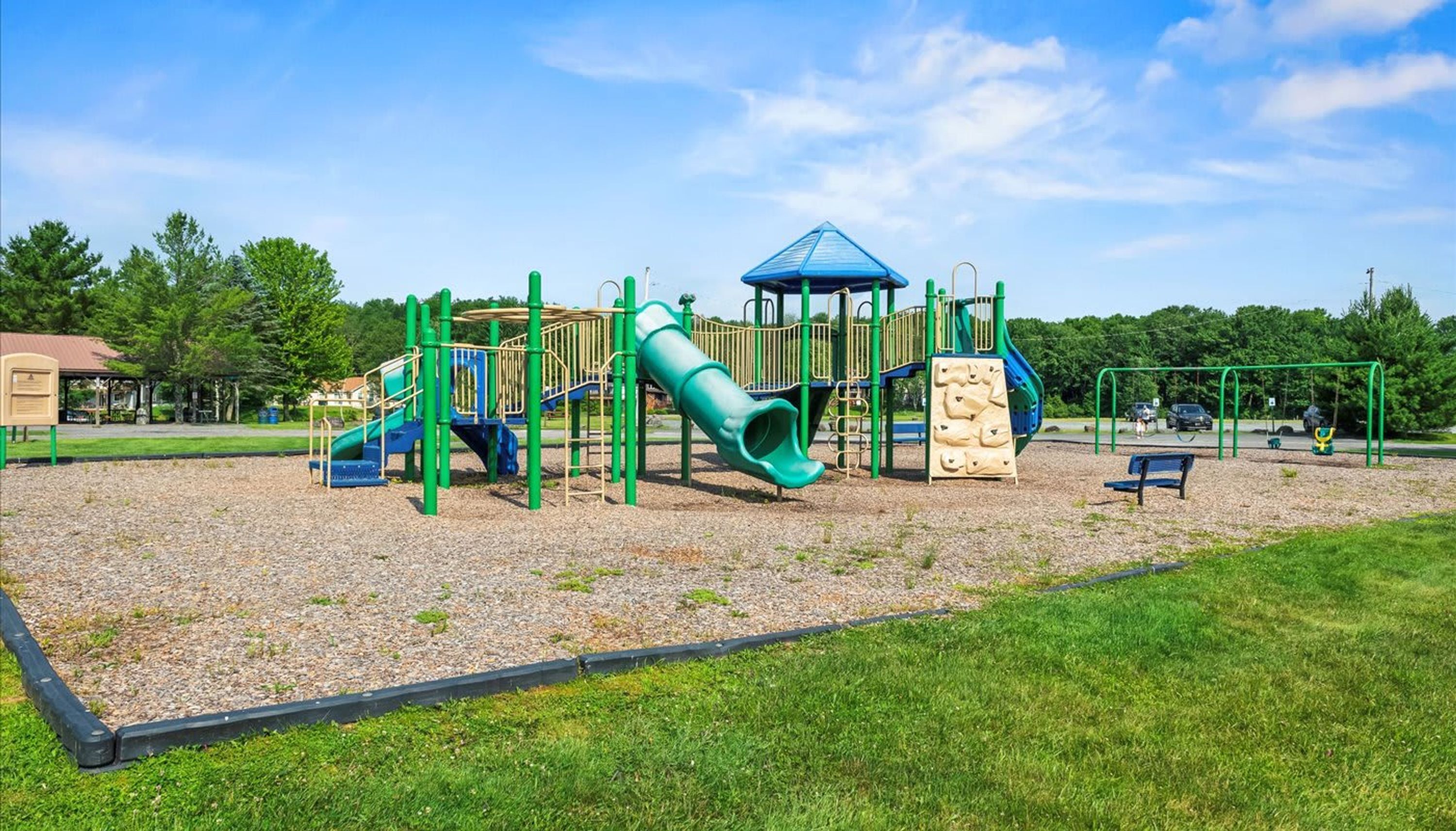 A playground with a slide, climbing structures, and a covered play area.