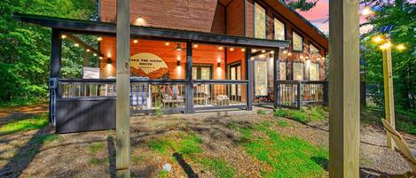 A wooden cabin with a covered porch and a sign reading 'TAKE THE SCENIC ROUTE.'