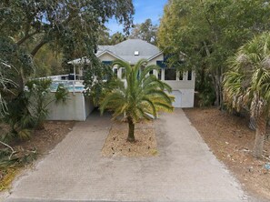 A residential property with a paved driveway leading to a house with a garage. - Coastal Luxe Retreat - Heated Pool - Games - Games (Hilton Head Island)