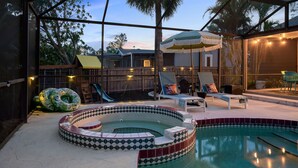 Ein Garten mit Swimmingpool, Whirlpool und Rutsche.