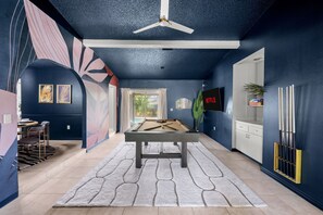 A room with a pool table, a ceiling fan, and a television mounted on the wall. - Family Retreat Pool Putt Putt Playground (Bradenton)
