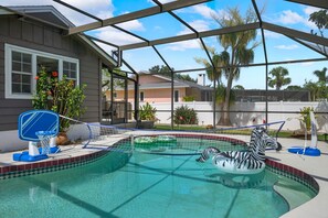 A pool with a safety net, a basketball hoop, and a zebra float. - Family Retreat Pool Putt Putt Playground (Bradenton)