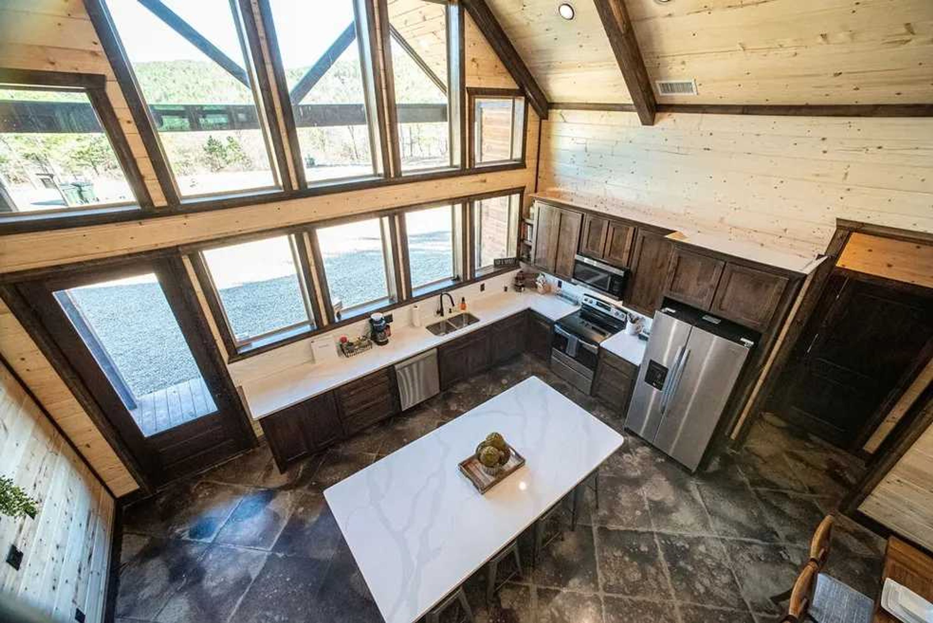 Una cocina amplia con ventanas grandes, una isla central y electrodomésticos modernos.