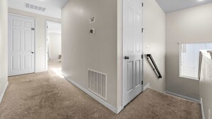 A hallway with carpeted floors, white walls, and doors leading to other rooms. - 6 Mins to Disney Game Themed Rooms Pool Spa (Kissimmee)