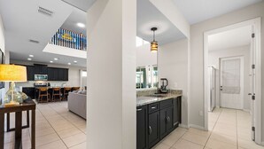 A modern kitchen with dark cabinets, a granite countertop, and a built-in oven. - 6 Mins to Disney Game Themed Rooms Pool Spa (Kissimmee)