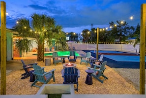 An outdoor patio area with Adirondack chairs, a fire pit, and a swimming pool. - Sleeps 10 Pickleball Pool Tiki Bar Games (Bradenton)