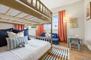 A room with a bunk bed, a sofa, a small table, and a lamp. - Sleeps 10 Pickleball Pool Tiki Bar Games (Bradenton)
