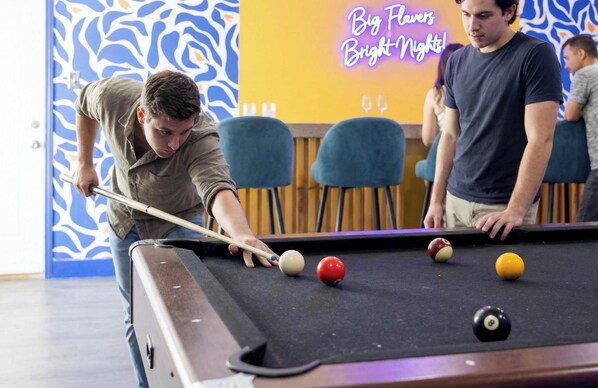 A pool table with balls and a cue stick, a neon sign reading 'Big Flavors Bright Nights!', and a patterned wall. - Outdoor Oasis Poolside Movie Nights Sleeps 16 (San Antonio)