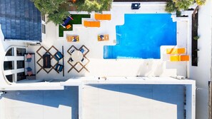 A rooftop pool area with a large swimming pool, multiple lounge chairs, and a seating area with tables. - Outdoor Oasis Poolside Movie Nights Sleeps 16 (San Antonio)