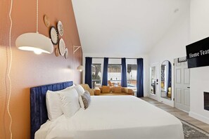 A hotel room with a large bed, a sofa, a dining area, and a TV. - Outdoor Oasis Poolside Movie Nights Sleeps 16 (San Antonio)