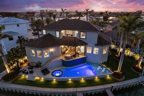 A two-story house with a swimming pool, outdoor seating, and a view of the surrounding neighborhood. - St Pete Waterfront Getaway Dock Pool (St. Petersburg)