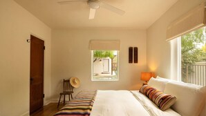 A bedroom with a bed, a chair, a window, and a ceiling fan. - The Tucson Bungalow Sam Hughes Pueblo (Tucson)