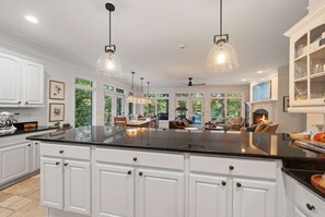 A spacious kitchen with a large island, white cabinetry, and pendant lighting. - The Sinclair House Private Lake Retreat (Milledgeville)