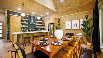 A wooden interior with a dining area, kitchen, and bar.