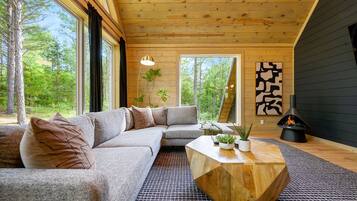 A modern interior with a sectional sofa, a wooden coffee table, and a fireplace.