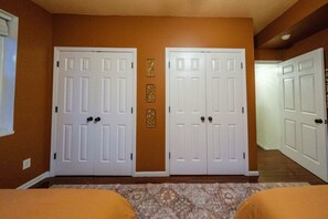 A hallway with double doors, a patterned rug, and a wall-mounted decoration. - Velvet Haus Downtown 3rd Floor Deck Backyard (Cincinnati)