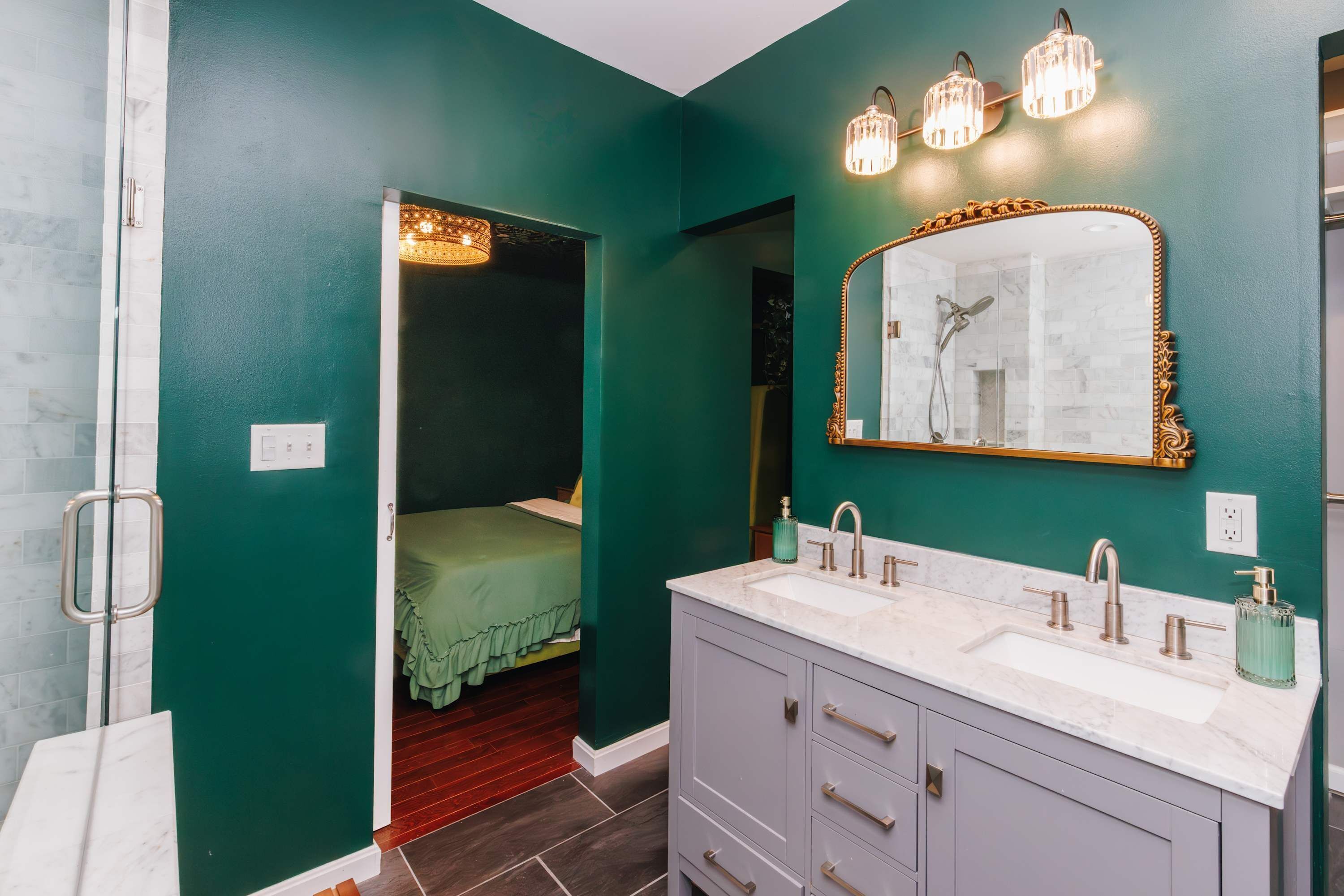 A bathroom with a large mirror, two sinks, and a shower.