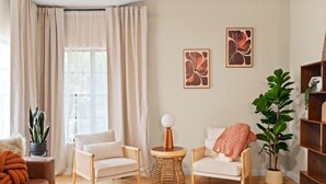 A living room with two armchairs, a round coffee table, a potted plant, and artwork on the wall. - The Ultimate Stay Play Retreat 4BR Sleeps 13 (Chandler)