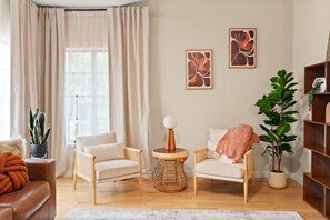 A living room with two armchairs, a round coffee table, a potted plant, and artwork on the wall. - The Ultimate Stay Play Retreat 4BR Sleeps 13 (Chandler)
