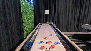 A shuffleboard table with numbered scoring areas and pucks. - The Ultimate Stay Play Retreat 4BR Sleeps 13 (Chandler)