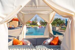A pool area with a covered seating area and a view of the pool. - The Ultimate Stay Play Retreat 4BR Sleeps 13 (Chandler)
