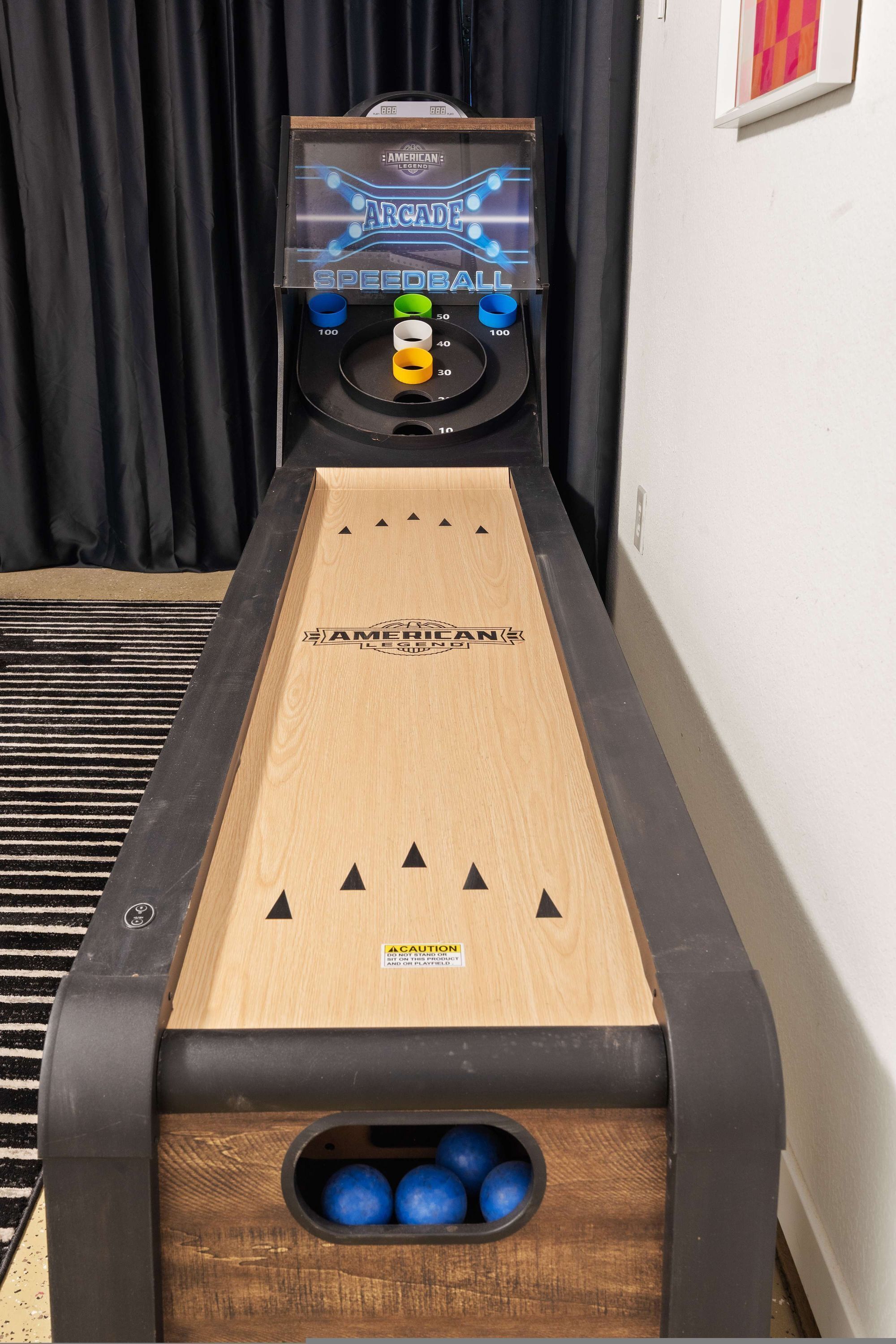 A shuffleboard table with a wooden surface and a caution sign.