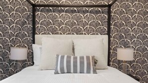 A bedroom with a canopy bed, two bedside lamps, and patterned wallpaper. - The Ultimate Stay Play Retreat 4BR Sleeps 13 (Chandler)