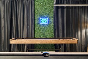 A pool table with a neon sign reading 'GAME ROOM' against a backdrop of black curtains and a green wall. - The Ultimate Stay Play Retreat 4BR Sleeps 13 (Chandler)