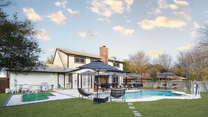 A backyard with a swimming pool, patio furniture, and a house. - Texas Tranquility Hot Tub Pool Putt Putt More (San Antonio)