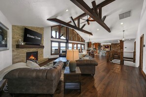A spacious living room with a fireplace, leather sofas, and a television labeled 'Home Team.' - Lakefront Oasis Private Dock Pool Sleeps 20 (Sunrise Beach)