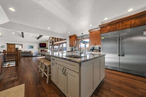 A spacious kitchen with a large island, stainless steel appliances, and wooden cabinetry. - Lakefront Oasis Private Dock Pool Sleeps 20 (Sunrise Beach)
