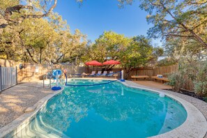A backyard with a swimming pool, a wooden deck, and a fenced area. - Sleeps 14 Pool Hot Tub Near Airport (San Antonio)