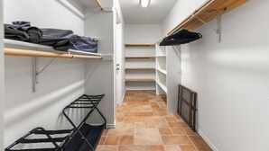 En smal gang med reoler langs begge sider, en radiator til højre og en dør i enden.