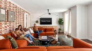 Ein Wohnzimmer mit einer karierten Wand, einem Sofa, einem Couchtisch und einem Schild mit der Aufschrift 'Home Team'.