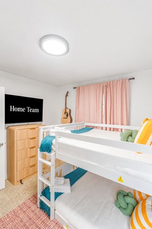 A child's bedroom with bunk beds, a guitar, a television, and a wardrobe. - Austin Encore Pool Hot Tub Putt-putt (Austin)