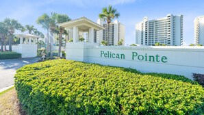 A sign for Pelican Pointe with a well-maintained hedge in the foreground. - Beach Front 7th Floor Views Pools Hot Tub (Orange Beach)