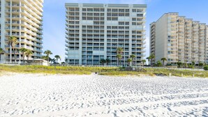 A beachfront hotel with multiple floors, balconies, and a sandy beach in the foreground. - Beach Front 7th Floor Views Pools Hot Tub (Orange Beach)