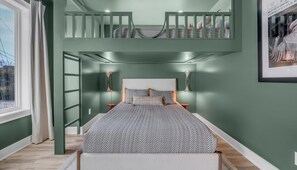 Um quarto com uma cama beliche, uma janela grande e um quadro pendurado na parede.