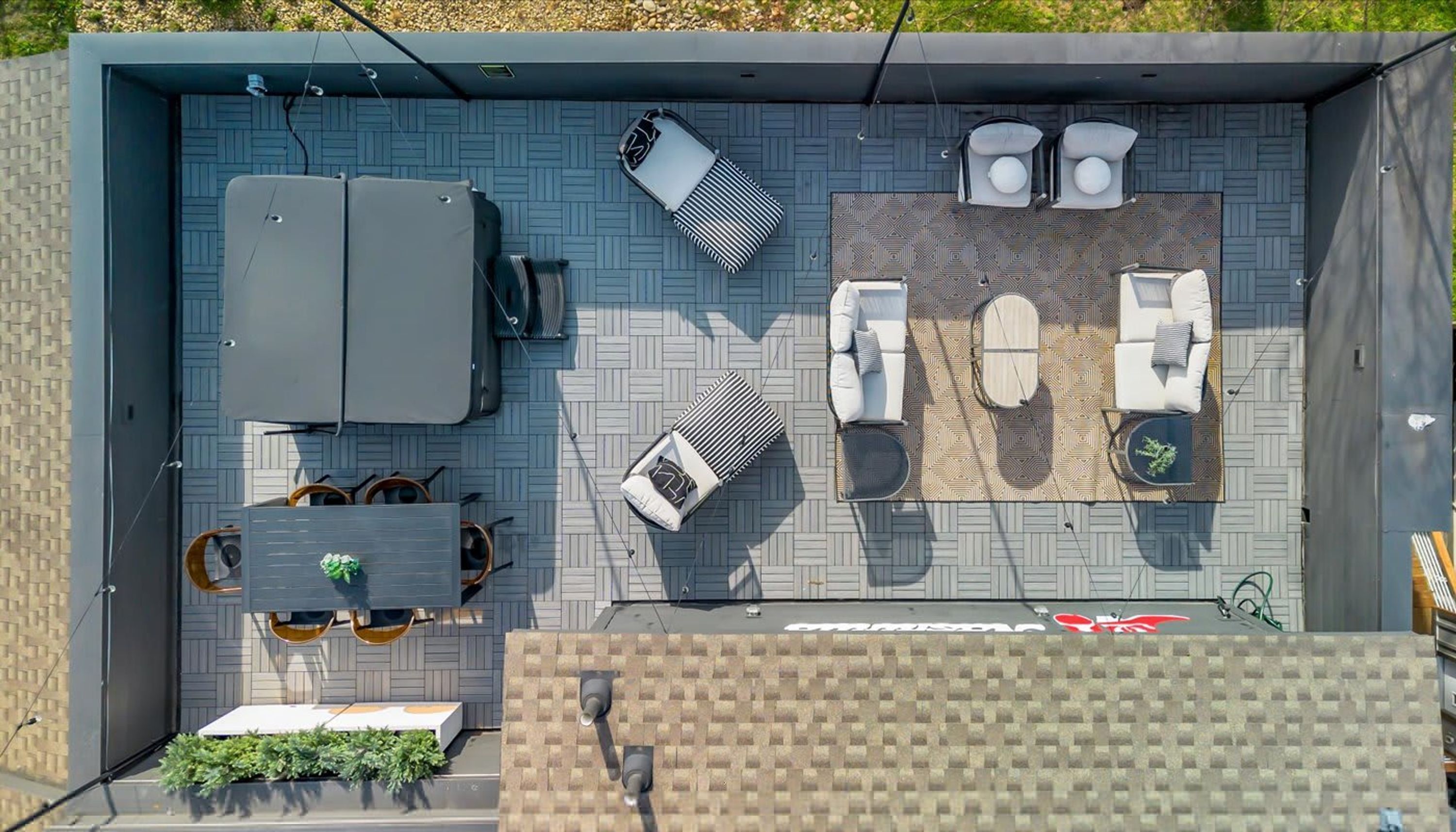 Eine Dachterrasse mit Esstisch, zwei Liegestühlen, einer Couch und einer kleinen Sitzecke.