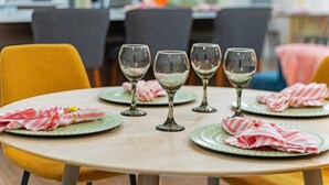 Un tavolo da pranzo con quattro bicchieri da vino e piatti, ognuno accompagnato da un tovagliolo a righe.