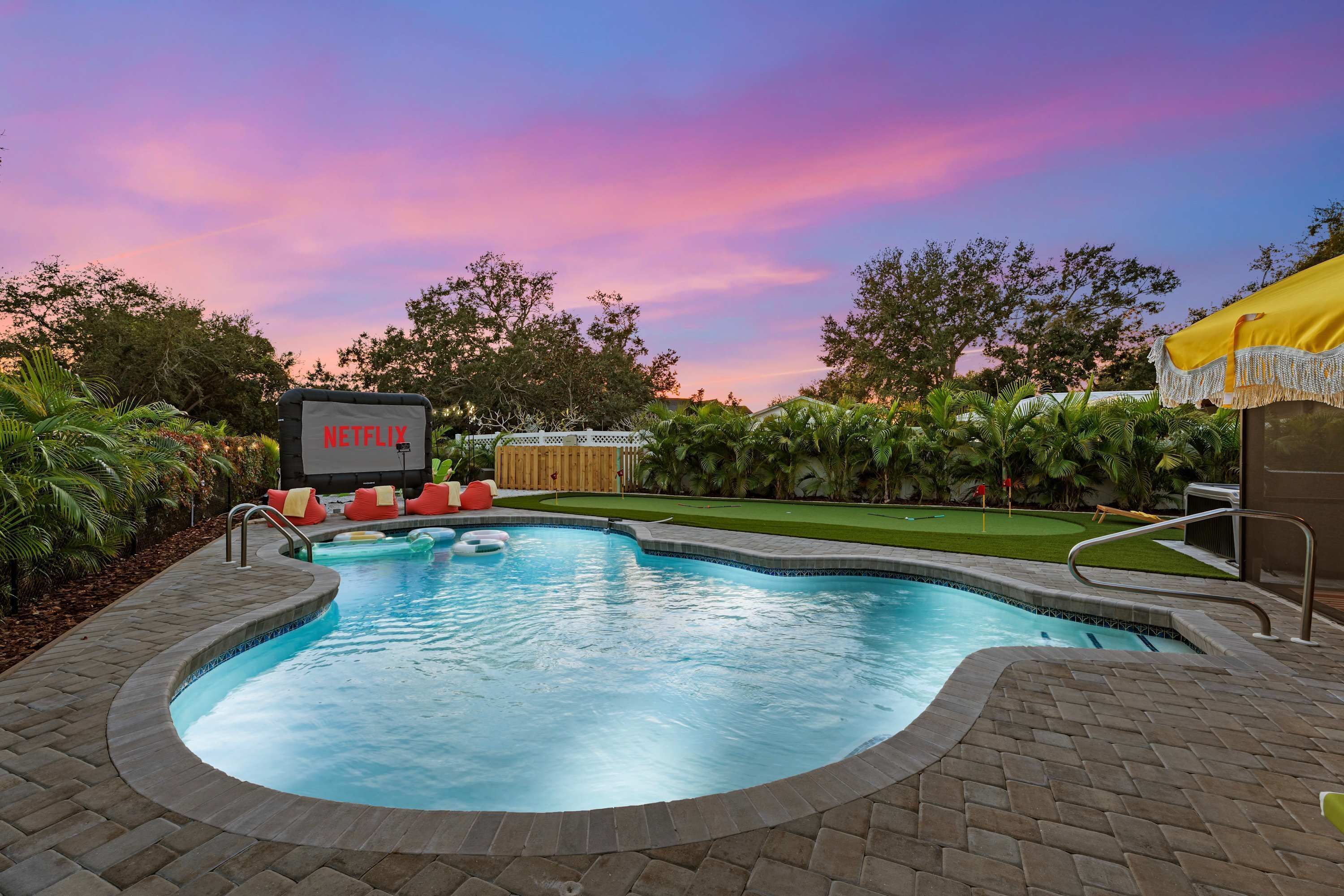 Una piscina con un cartel que dice 'NETFLIX' y una cerca de madera al fondo.